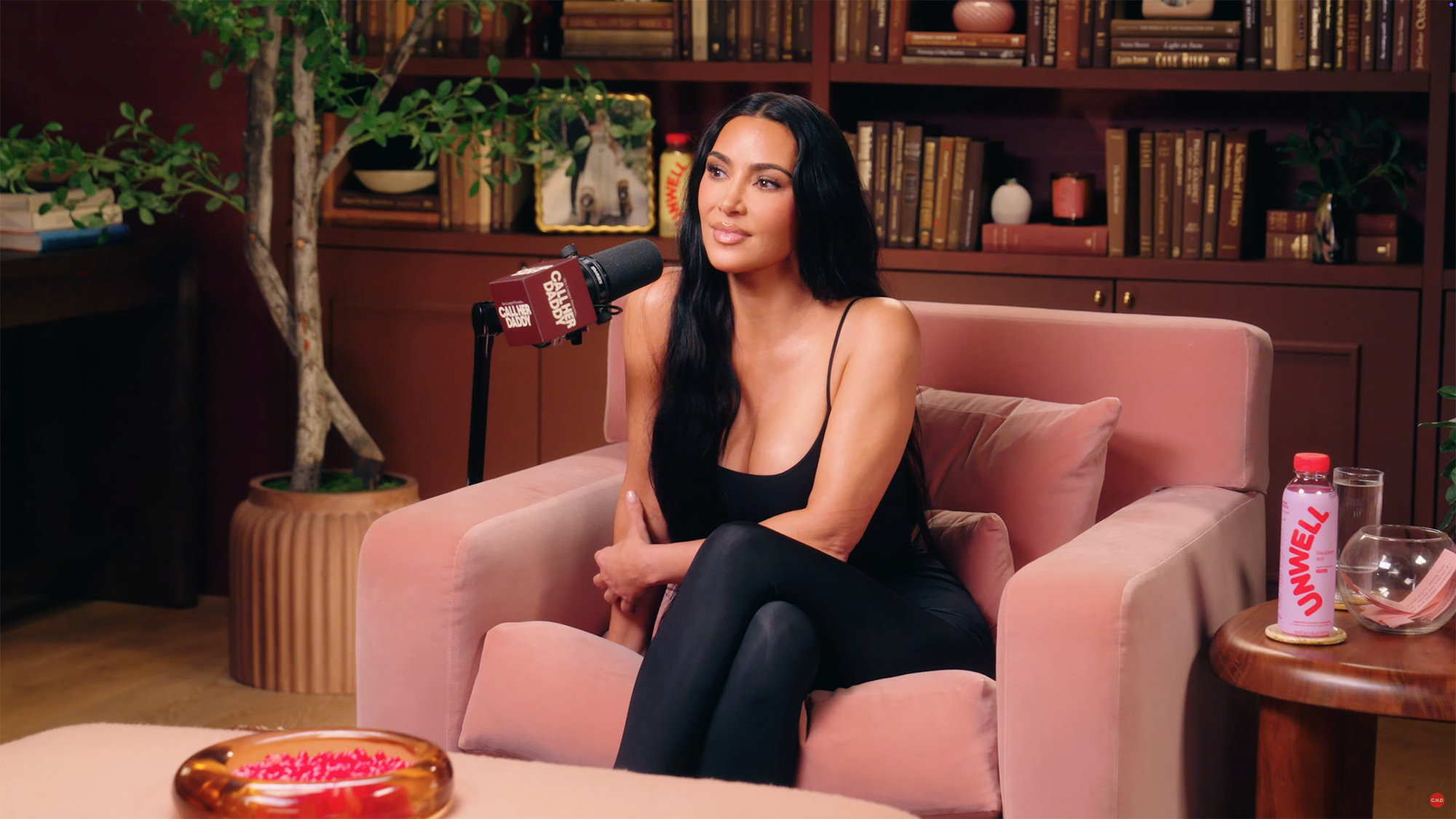Kim Kardashian sitting in a pink armchair during her appearance on the Call Her Daddy podcast.