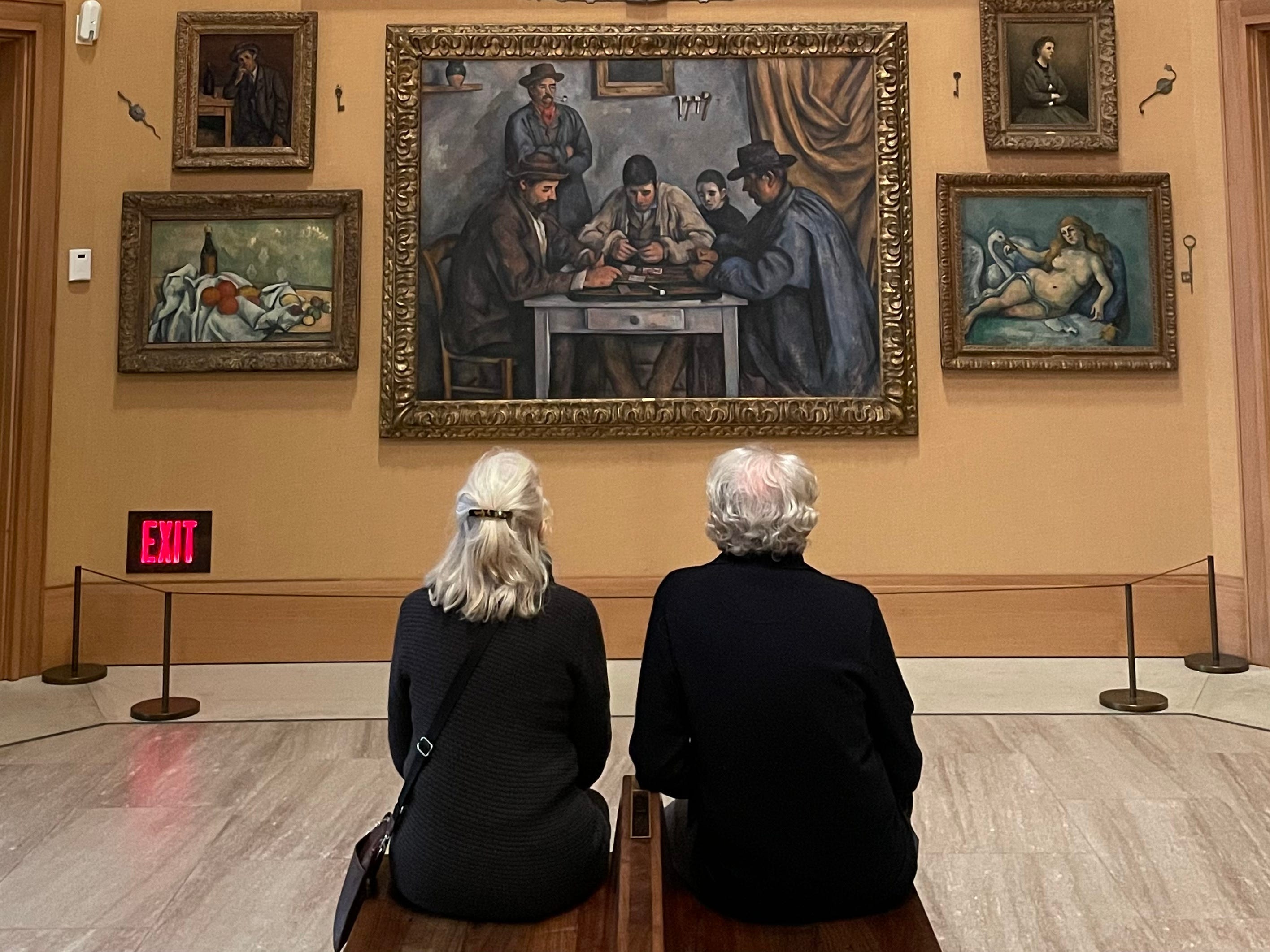 a couple sitting looking at paintings inside the philadelphia art museum