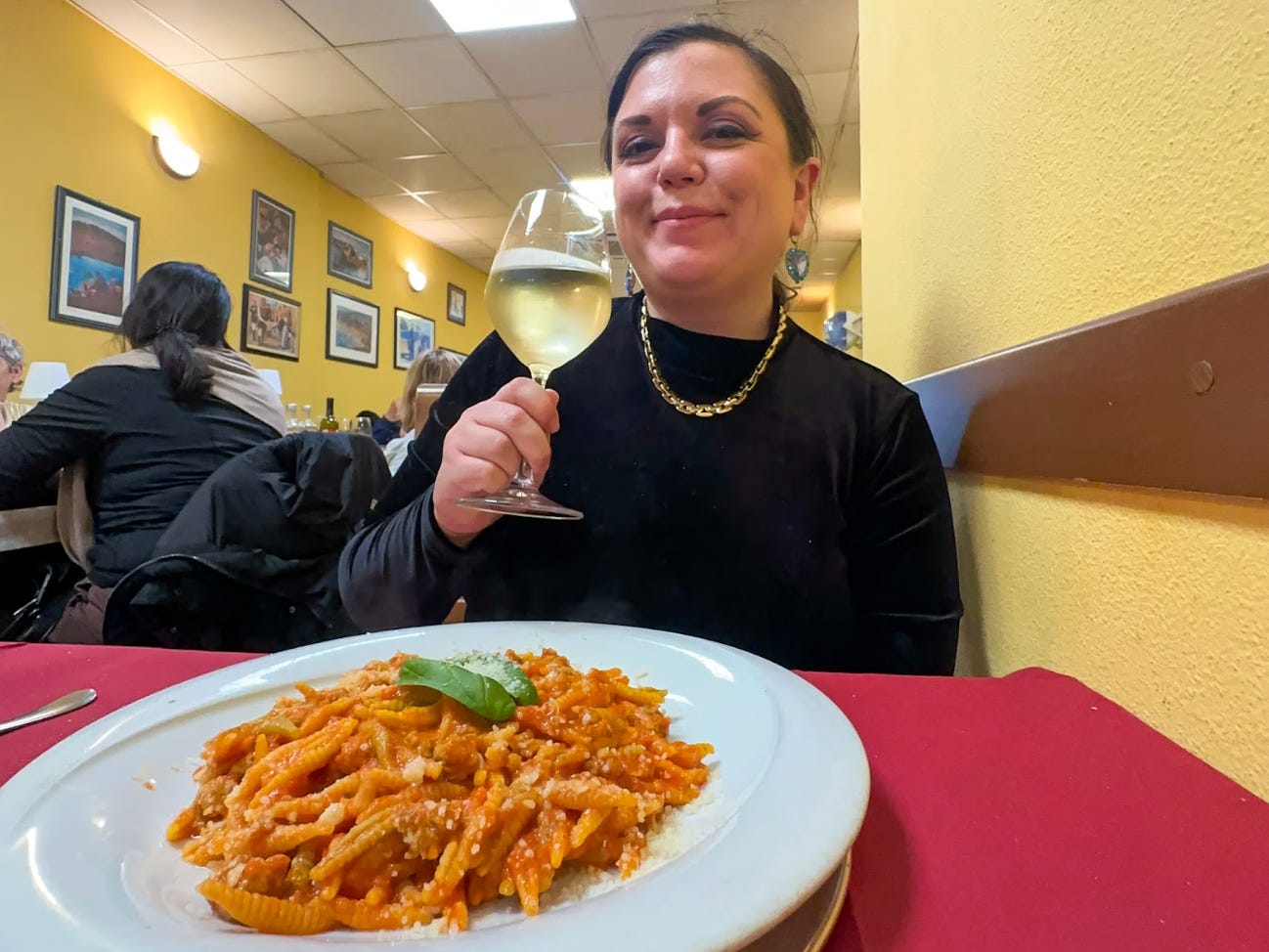 The writer eating pasta and drinking wine in Cagliari.
