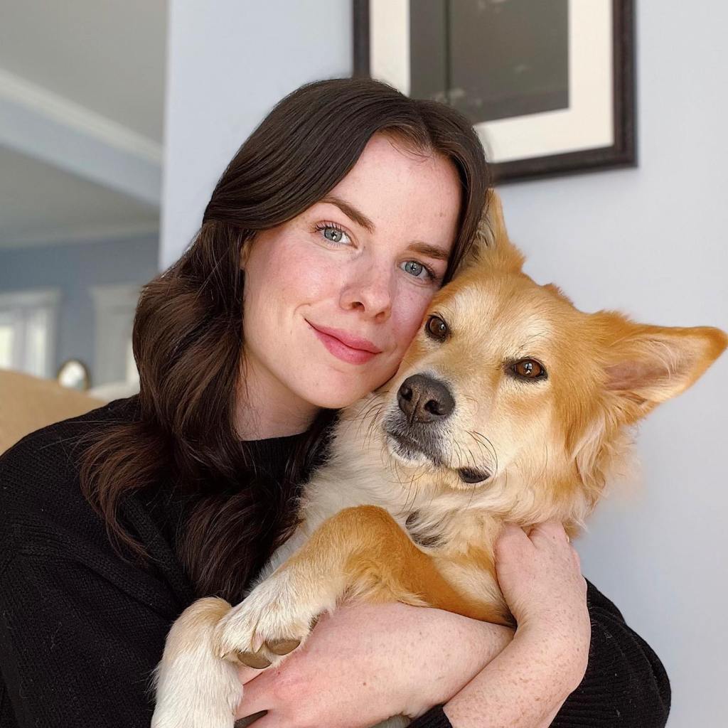 Isabel holding Simon, a golden-brown dog.