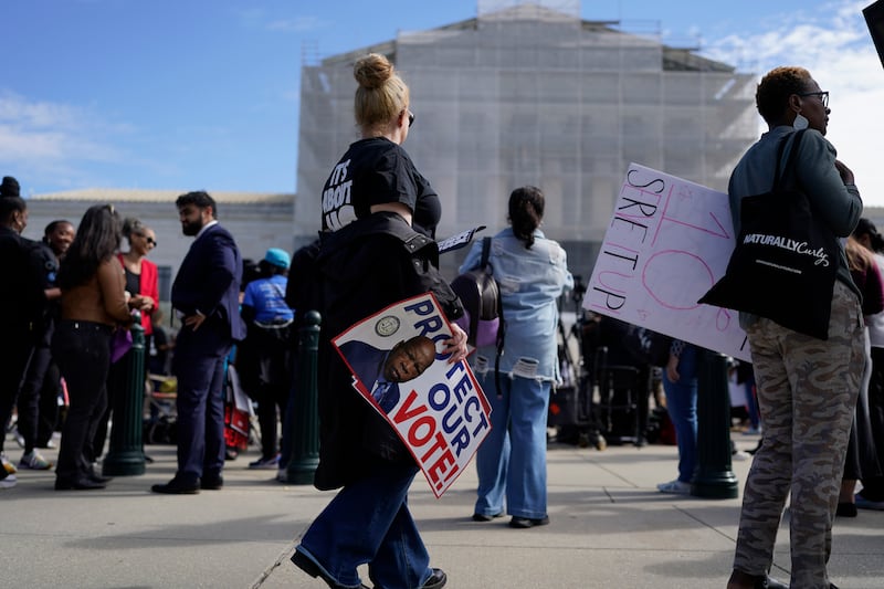 Activists protested outside as the Supreme Court heard arguments over a key provision of the Voting Rights Act of 1965.