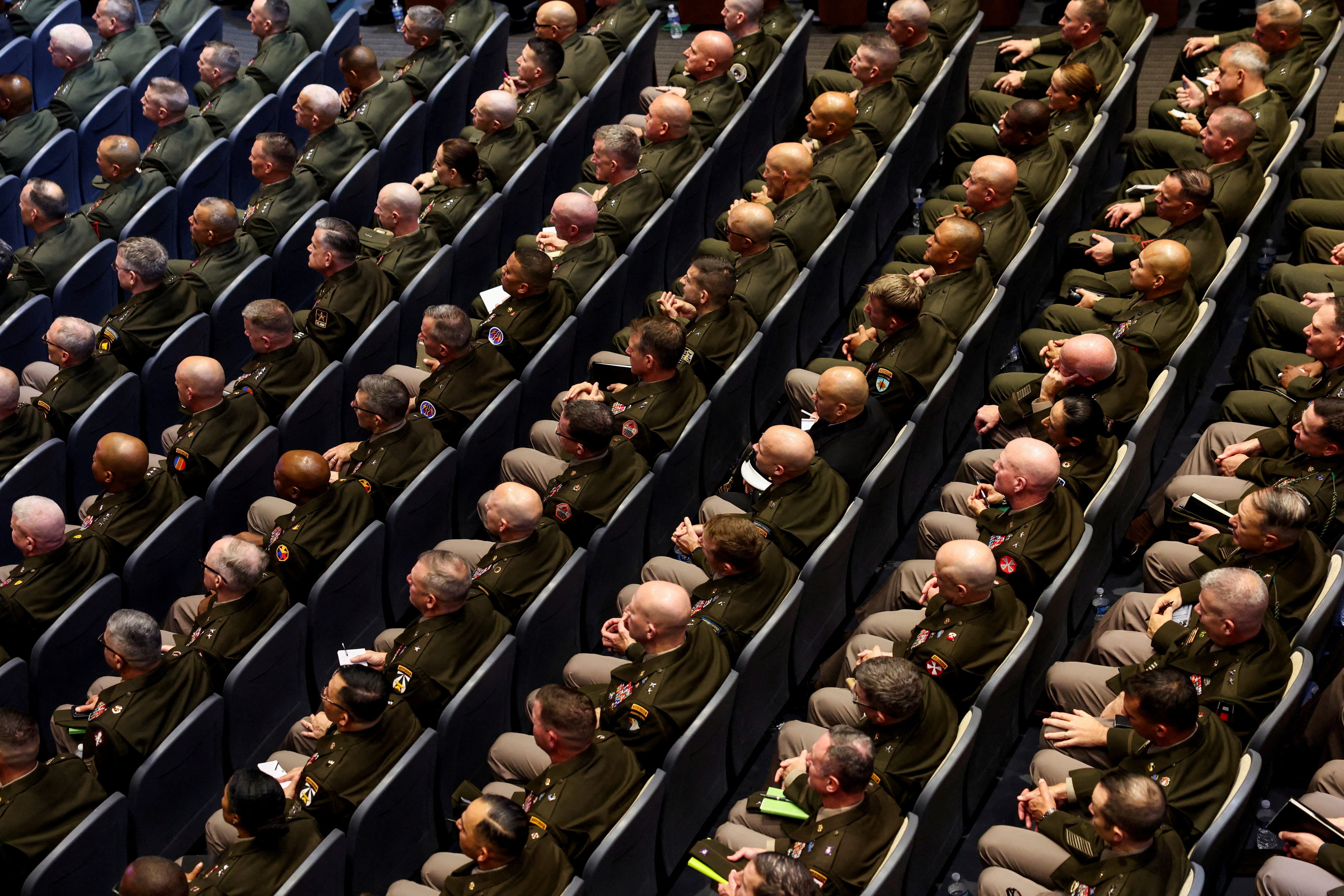 Rows of US military generals and admirals sit together in a theater.