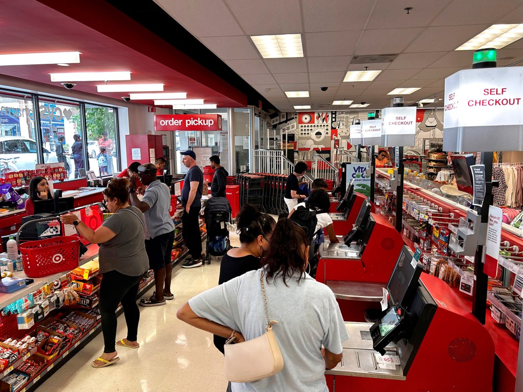 People waiting in lines at both self-checkout and cashier lines at a Target store.