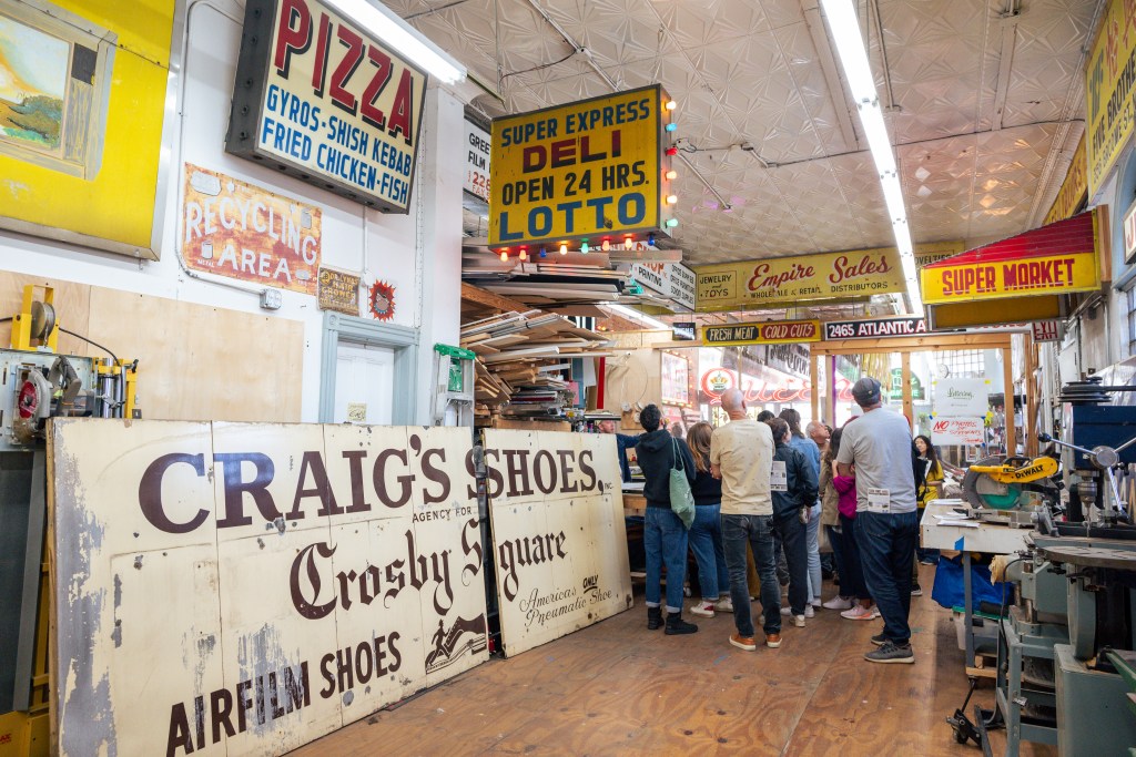 People viewing vintage signs at the New York Sign Museum.