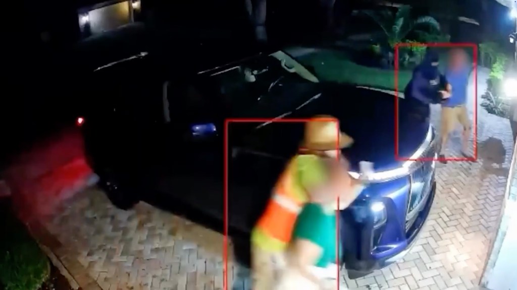 One of the burglar suspects wore a high-visibility safety vest as another wore darker clothing and a mask.