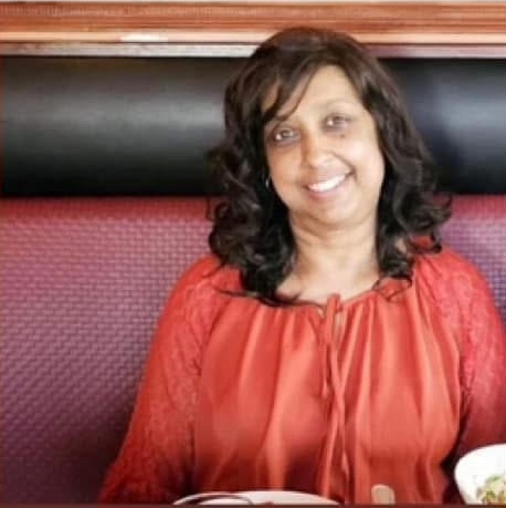 Lelawattie Narine, the pedestrian victim of a motorcycle collision, smiling in an orange top.