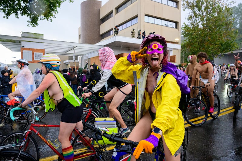 Participants in the Emergency World Naked Bike Ride pass by the U.S. Immigration and Customs Enforcement building on October 12, 2025 in Portland, Oregon.