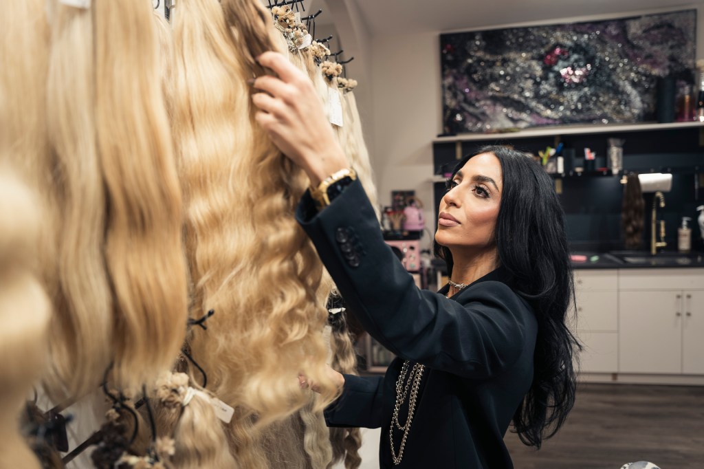 Ester Yuabova selecting natural hair extensions for a client.