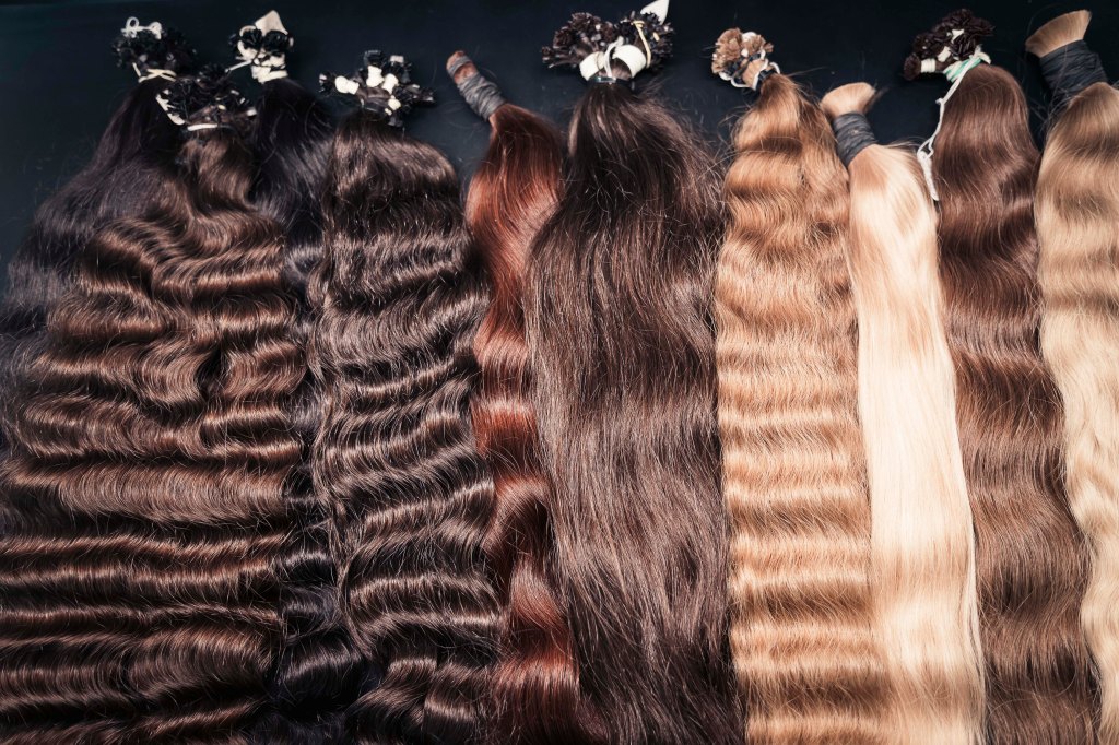Bundles of natural hair extensions in various colors and textures.