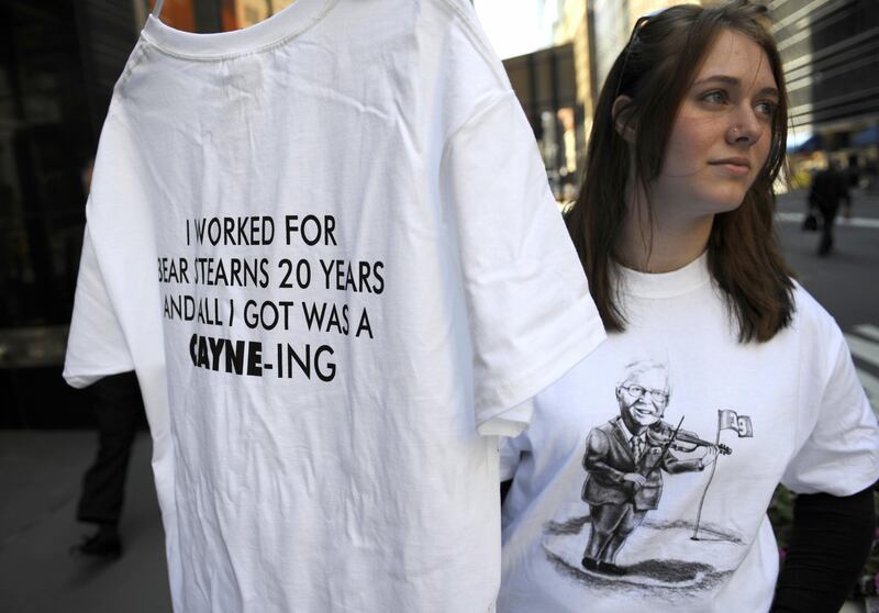 A relative of a former Bear Stearns employee displays T-shirt mocking Bear Stearns CEO James Cayne, in front of Bear Stearns headquarters in New York, May 29, 2008. Bear Stearns, the most high-profile victim of the US subprime property crisis, approved a deal to sell itself to banking giant JPMorgan Chase, a spokeswoman for the Wall Street firm said. AFP PHOTO/Emmanuel DUNAND (Photo credit should read EMMANUEL DUNAND/AFP via Getty Images)