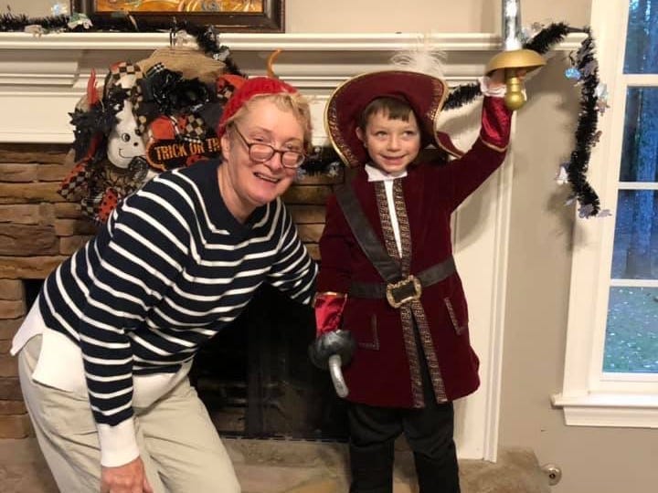 A grandma with her young grandson dressed as a musketeer.