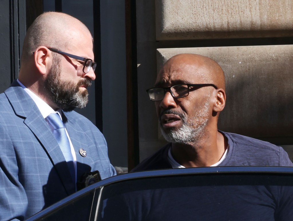Suspect Michael Benjamin, 57, being walked out of the Special Victims Unit.