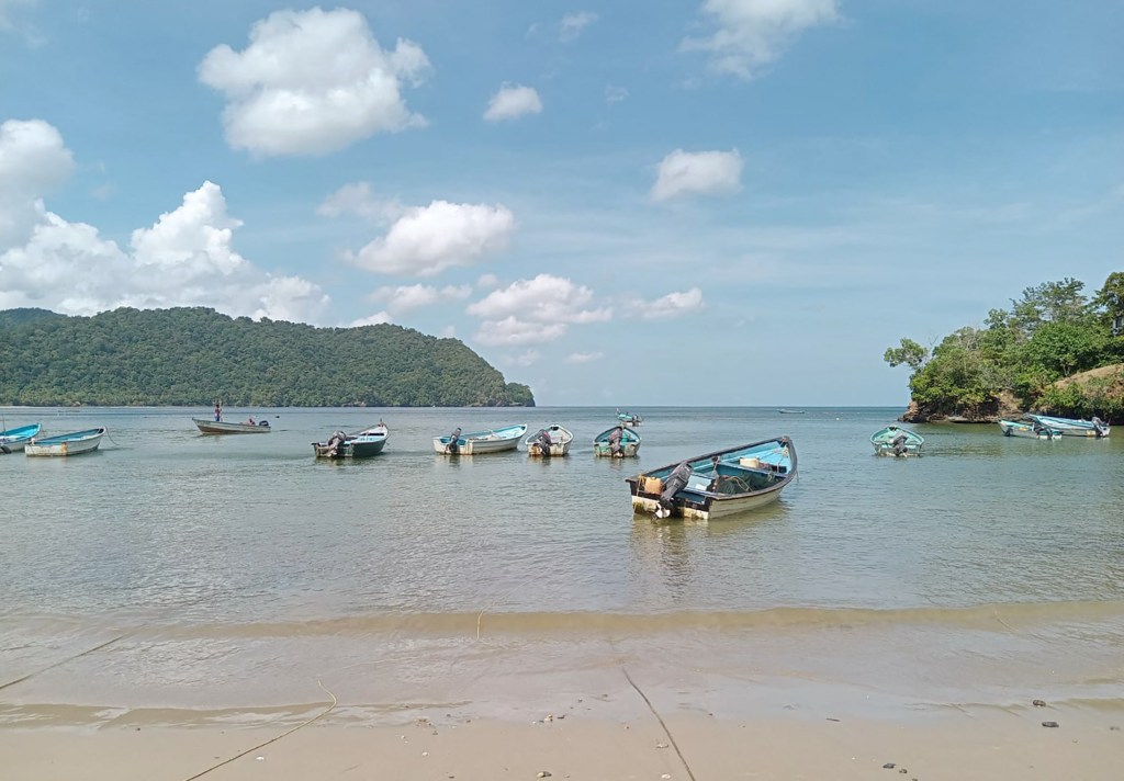 Boats anchored in the water at La Cueva Bay, Trinidad and Tobago.