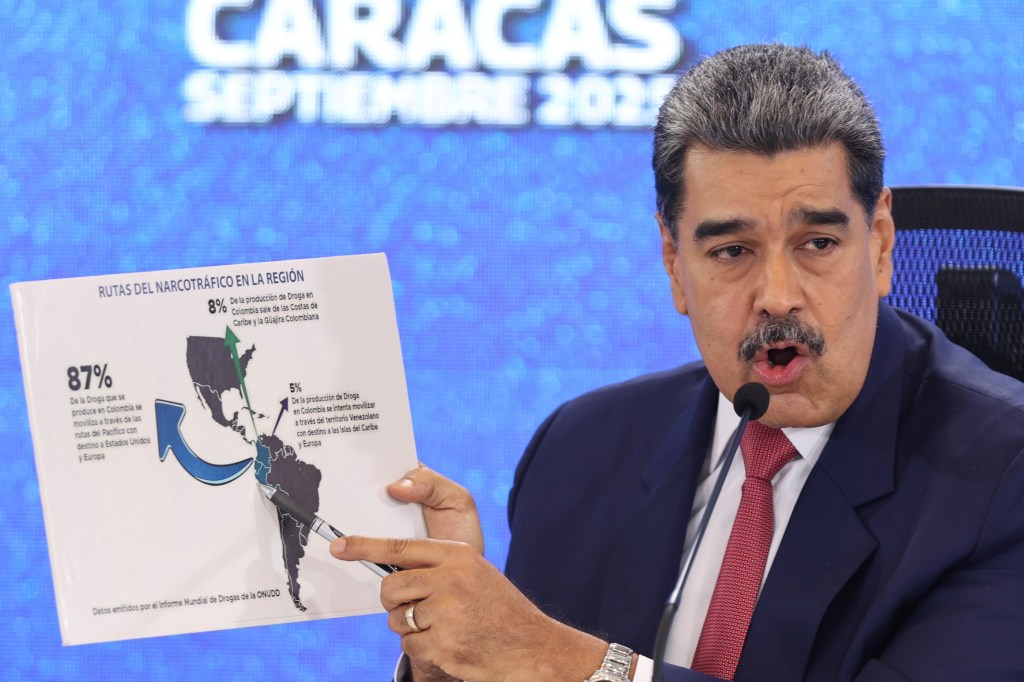 Venezuelan President Nicolas Maduro pointing at a map of the Americas illustrating drug trafficking routes.