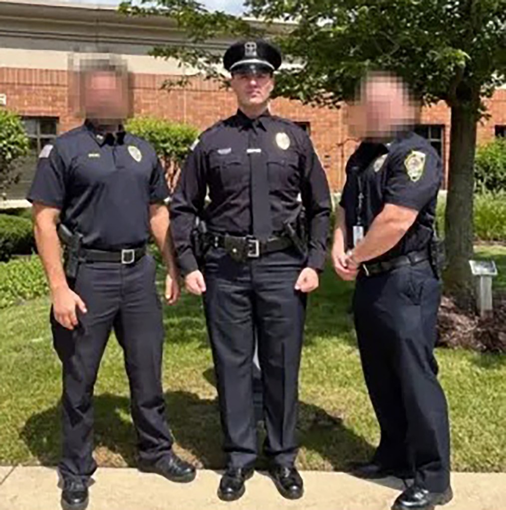 Three male police officers in uniform, with the two outer officers' faces blurred.