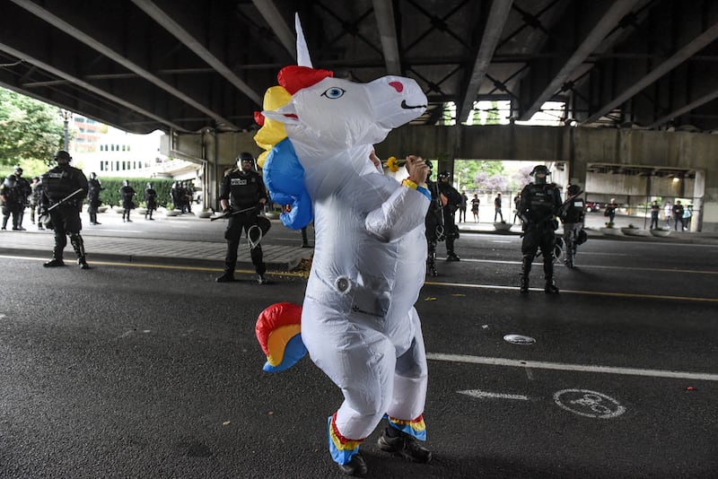 PORTLAND, OR - AUGUST 17: A person dressed as a unicorn dances in front of police officers during an alt-right rally on August 17, 2019 in Portland, Oregon. Anti-fascism demonstrators gathered to counter-protest a rally held by far-right, extremist groups. (Photo by Stephanie Keith/Getty Images)