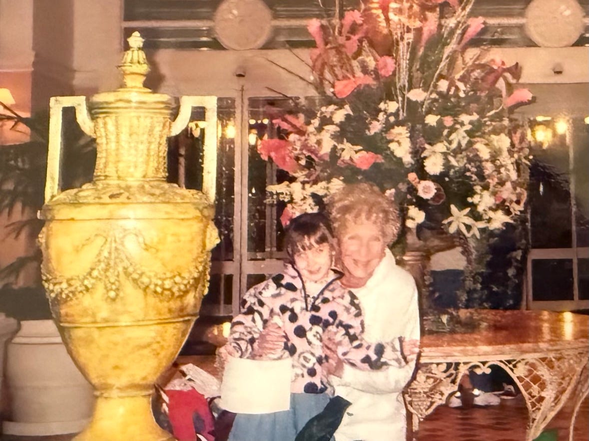Old photo of Author Tricia Patras as a child, smiling with her grandmother