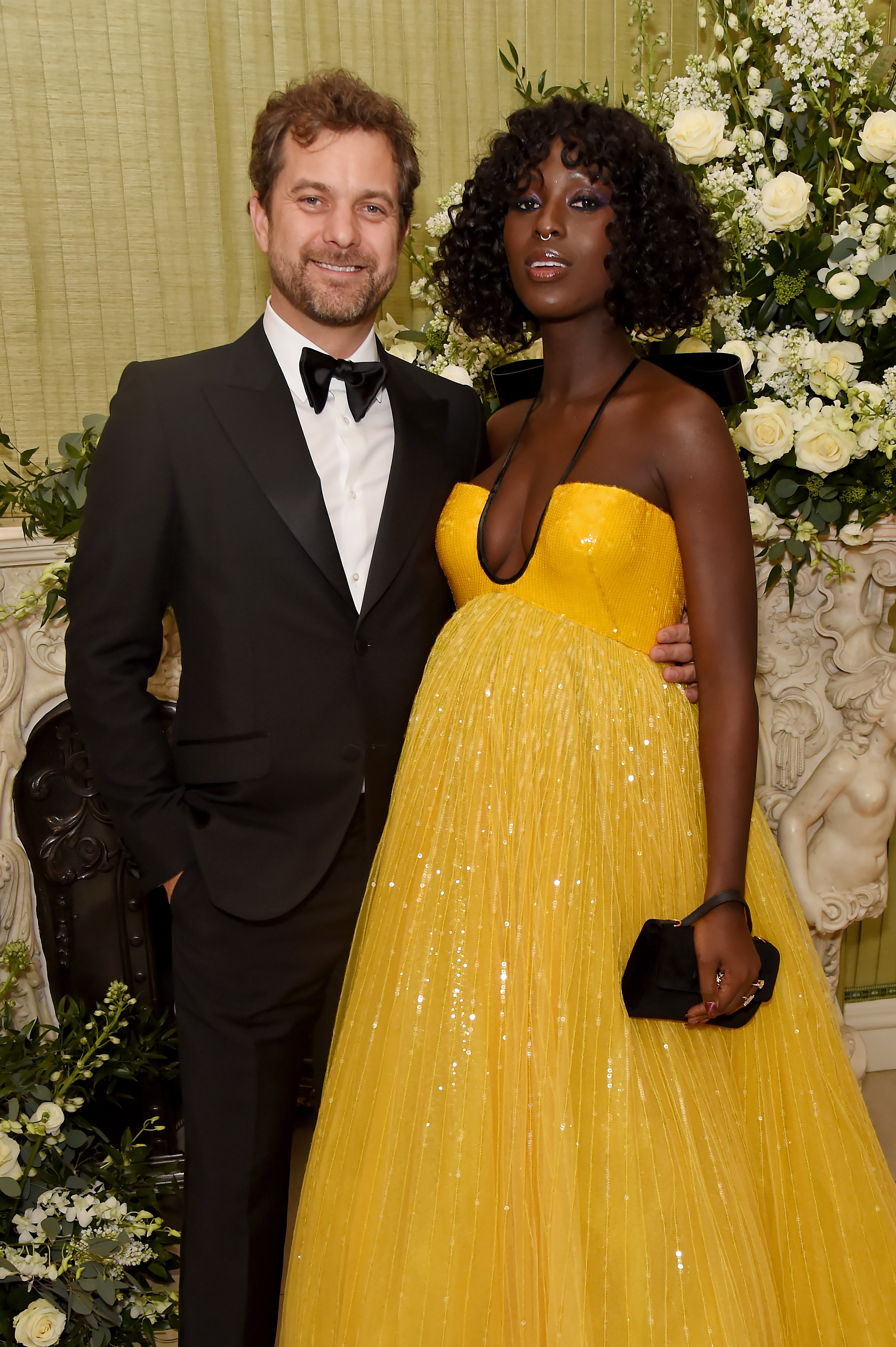 Joshua Jackson in a black tuxedo and Jodie Turner-Smith in a yellow dress.