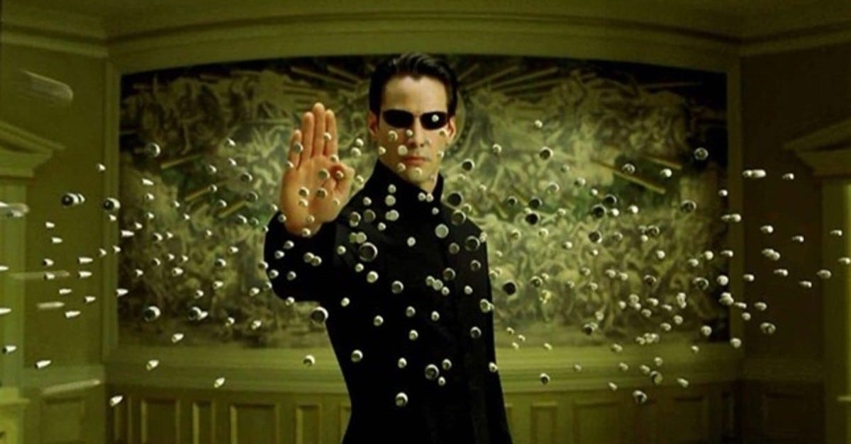 Keanu Reeves as Neo blocking bullets in The Matrix