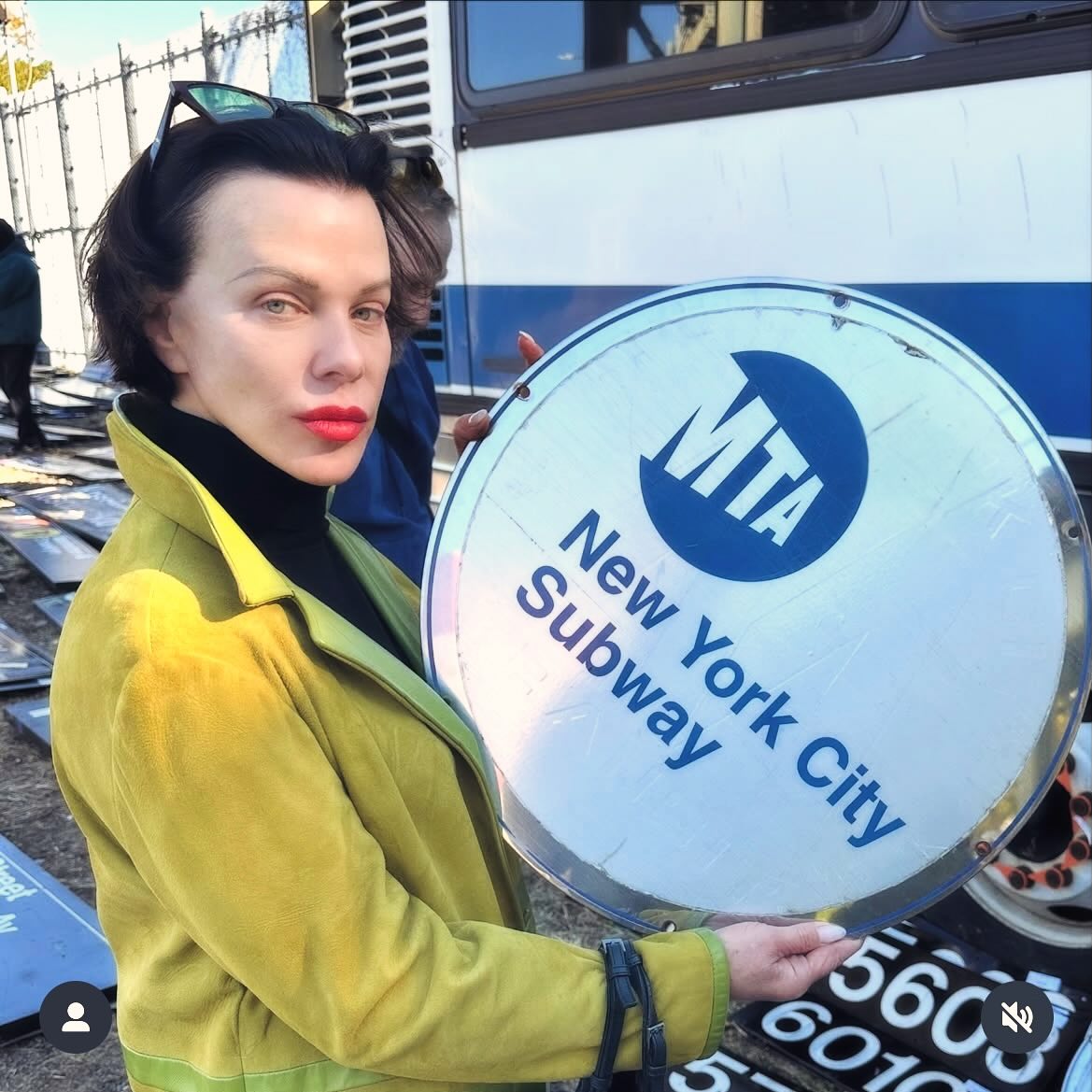Debi Mazar picks up a New York City subway sign at the MTA sale.