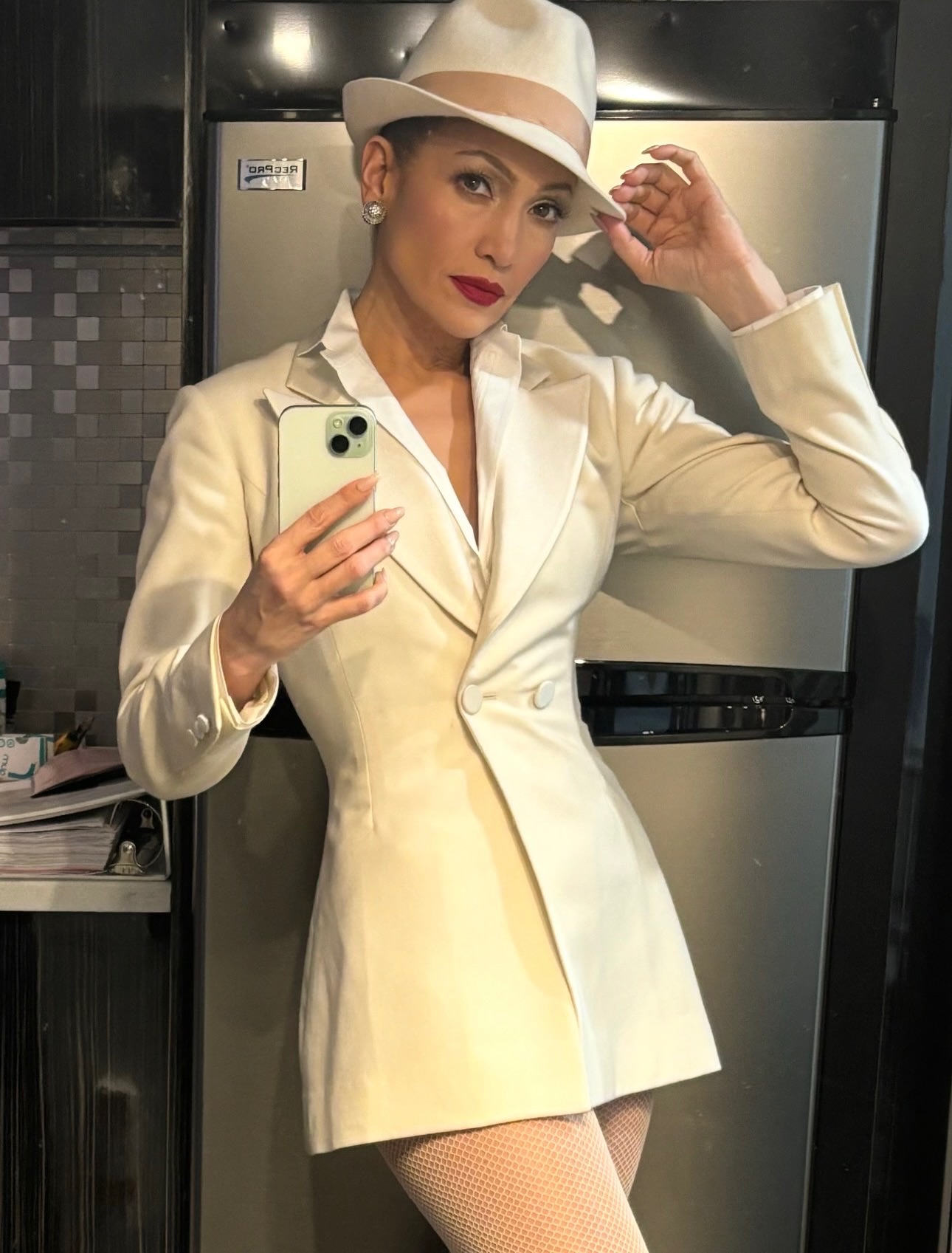 Jennifer Lopez snaps a selfie in a fedora and suit mini dress.