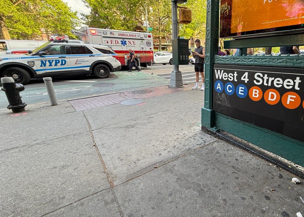 A police car and an ambulance are seen at the West 4th St. subway station in Manhattan, Friday, May 2, 2025. A man was stabbed on an F train during an argument with another person. 