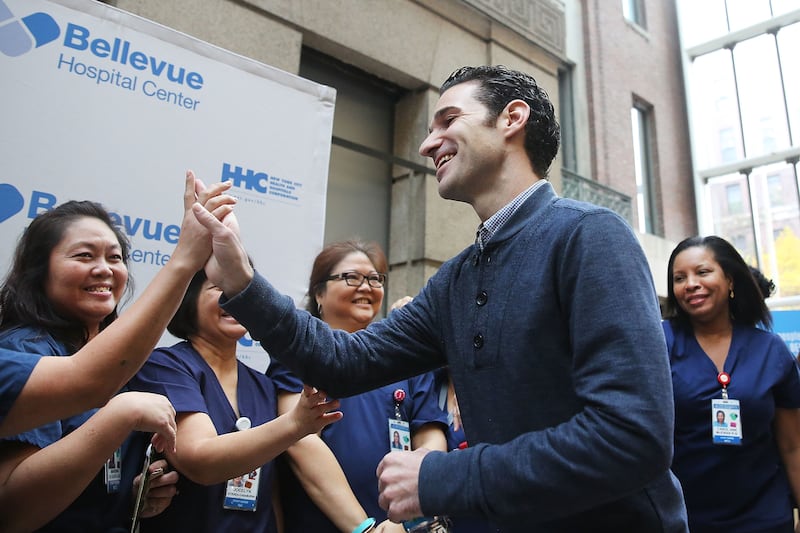 Dr. Craig Spencer, who was diagnosed with Ebola in New York City last month, greets some of the nurses who helped him to recovery