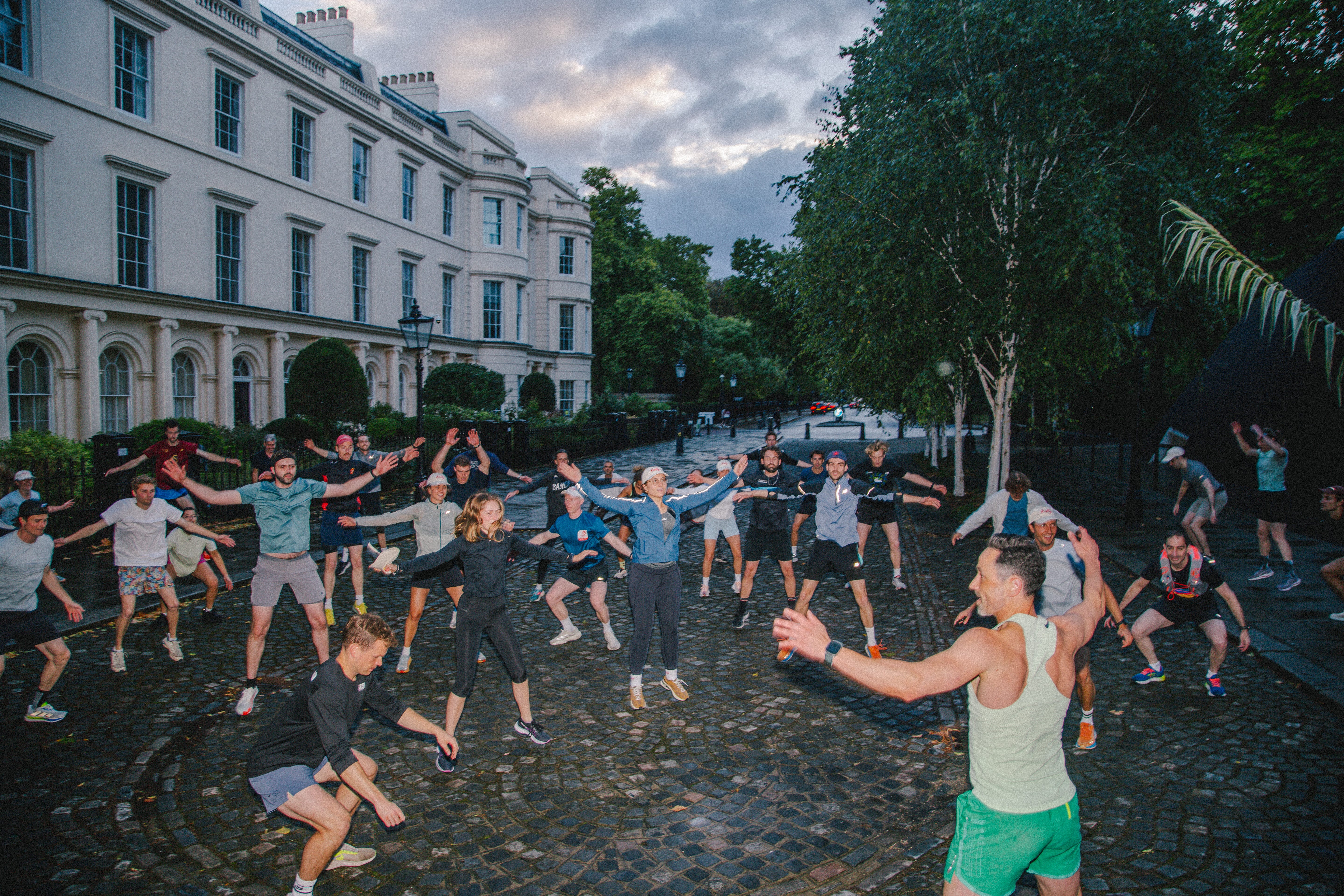 A group of people do a warm-up routine.