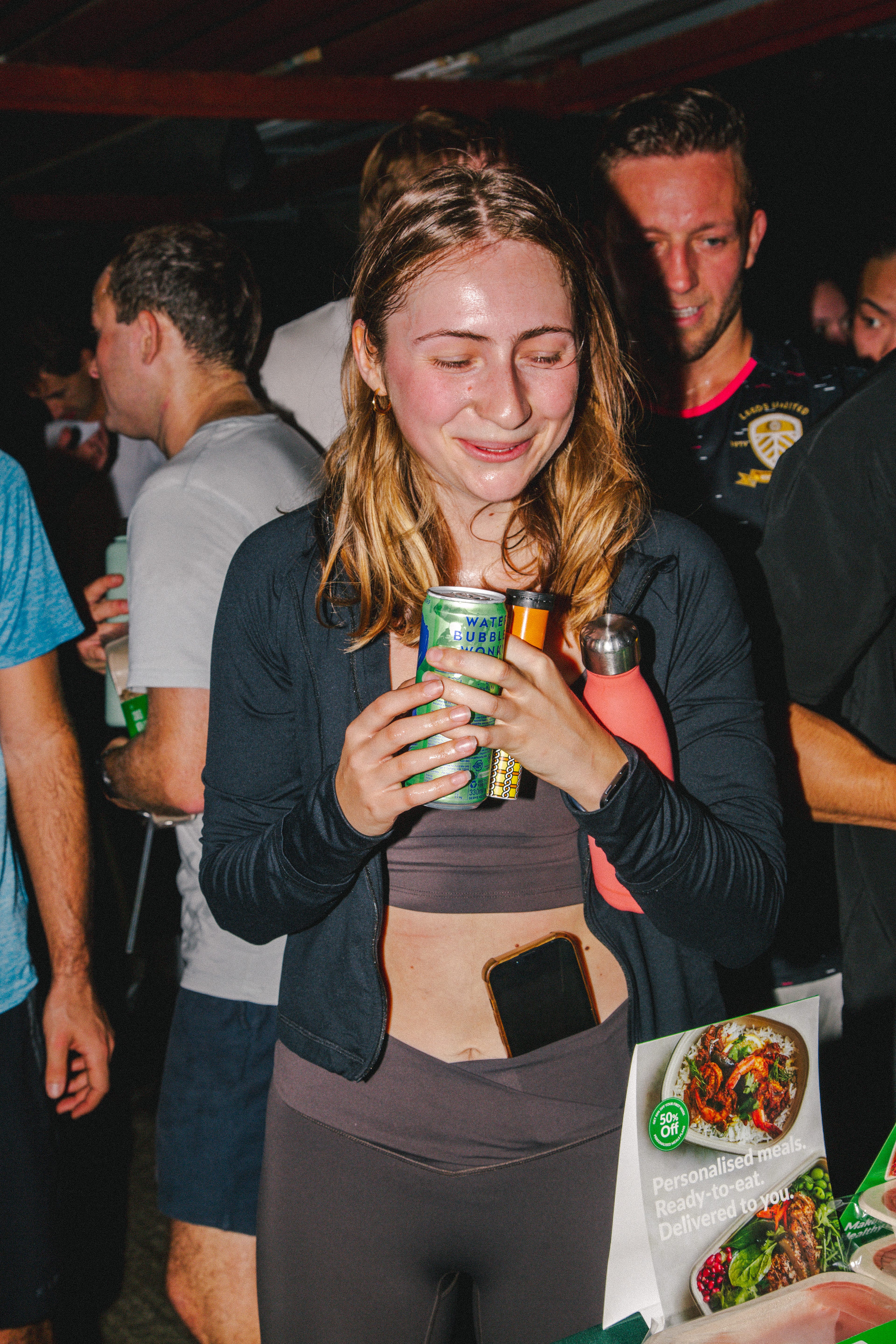 A woman holds a can of sparkling water.