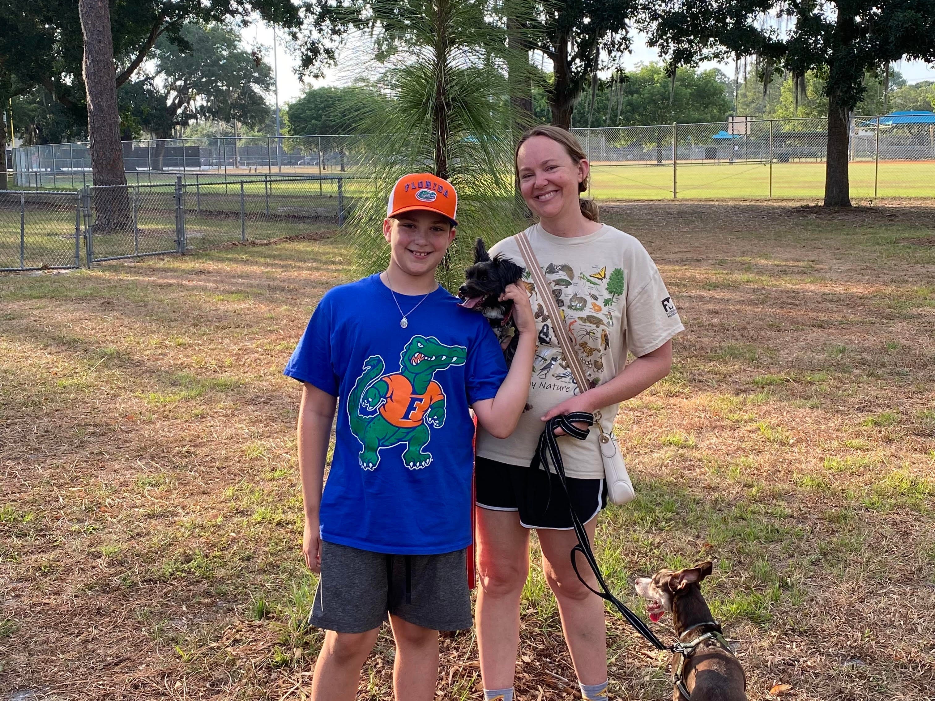 Author Ashley Archambault with her son in a park with dogs in Florida