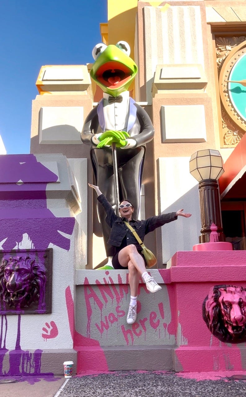 Author Simone Paget smiling in front of Kermit statue