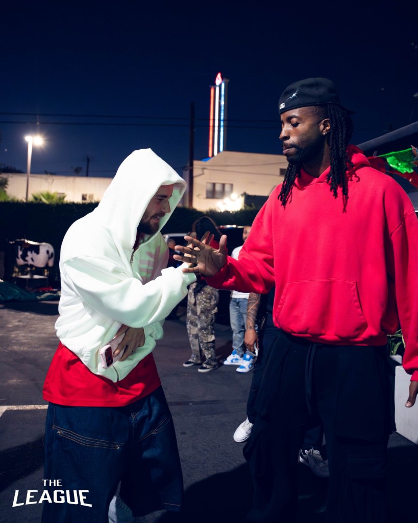 Justin Bieber greeting a man while outdoors at night.
