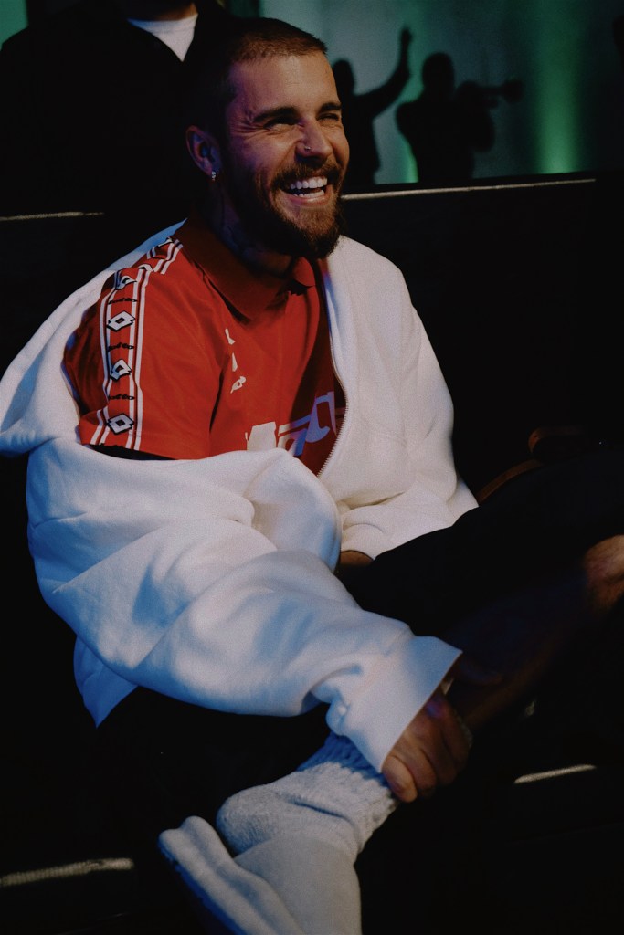 Justin Bieber smiling and pulling up his sock.