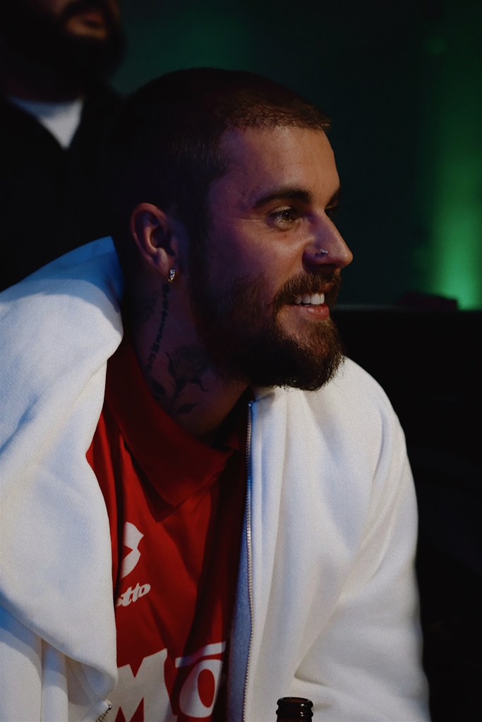 Justin Bieber in a red shirt and white jacket.