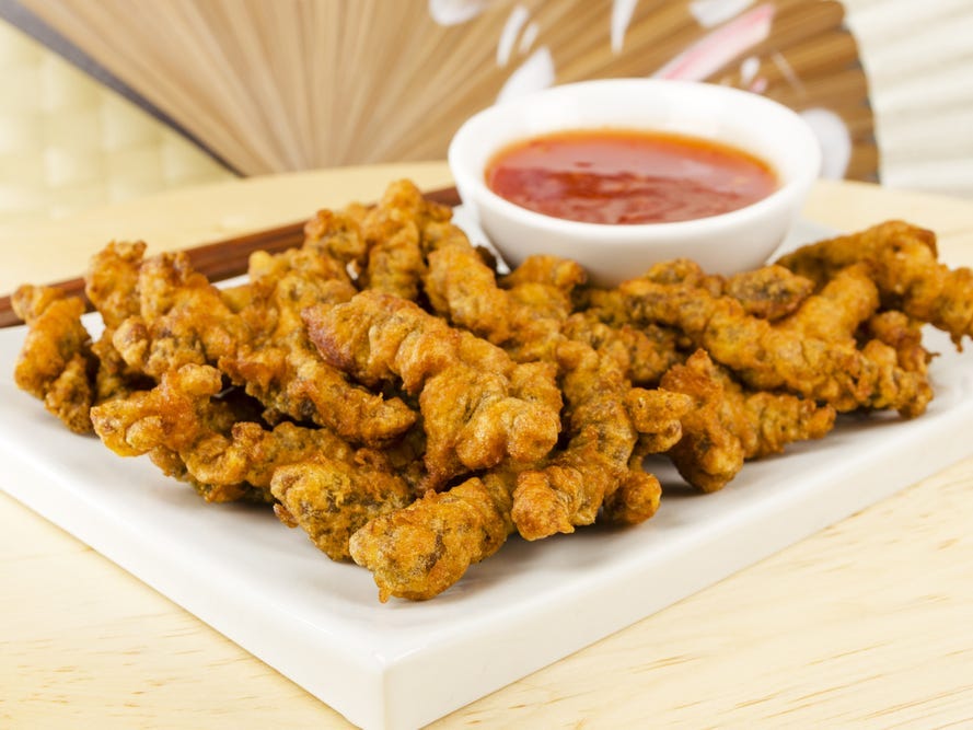 fried beef finger stakes on a white plate with sauce