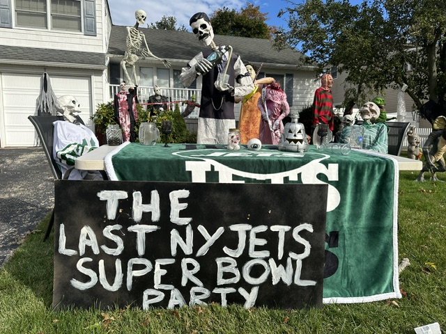 Halloween decorations at Aaron Lohman's Seaford, Long Island home with skeletons dressed as New York Jets fans at a table with a sign reading 