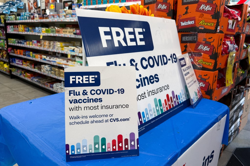 Signs advertising free flu and COVID-19 vaccines at a CVS pharmacy in New York.