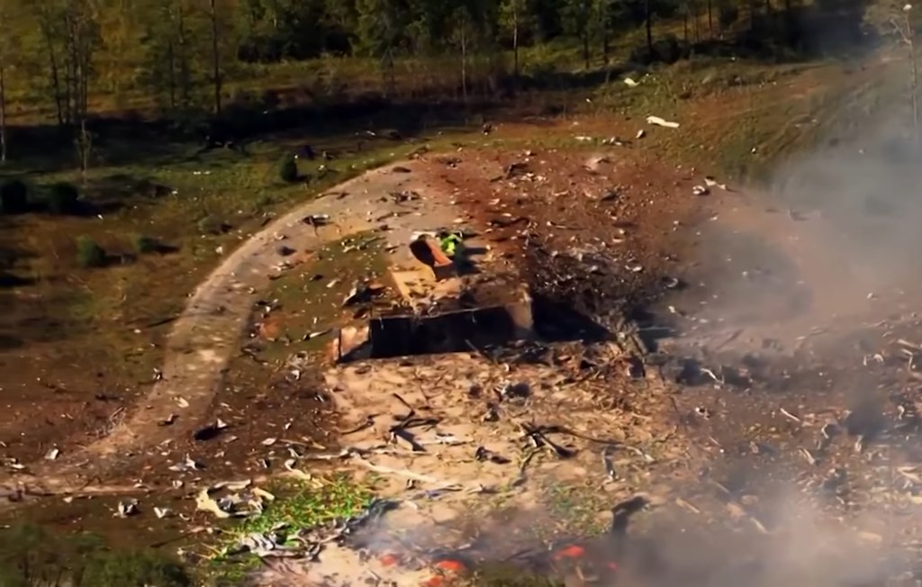 Aerial view of the Accurate Energetic Systems plant after an explosion, showing debris and smoke.