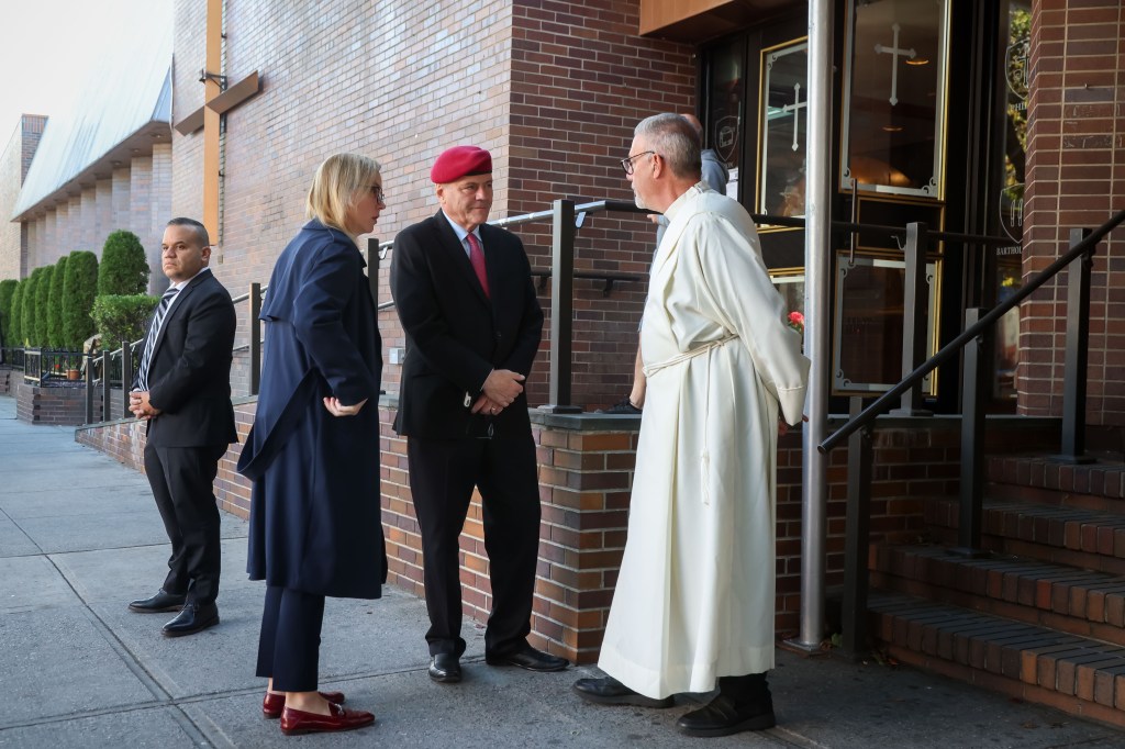 Curtis Sliwa talks with Deacon Anthony Mammoliti during Nicola Tanzi's funeral.