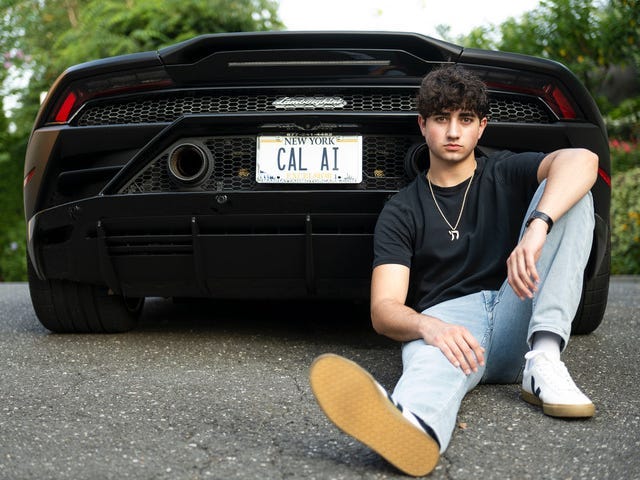 A young man sits on the ground in front of a black Lamborghini with a New York license plate reading