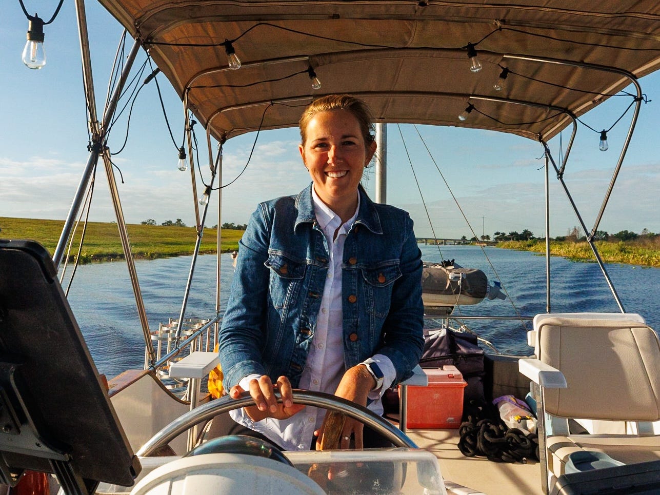 A woman behind the wheel of a boat.