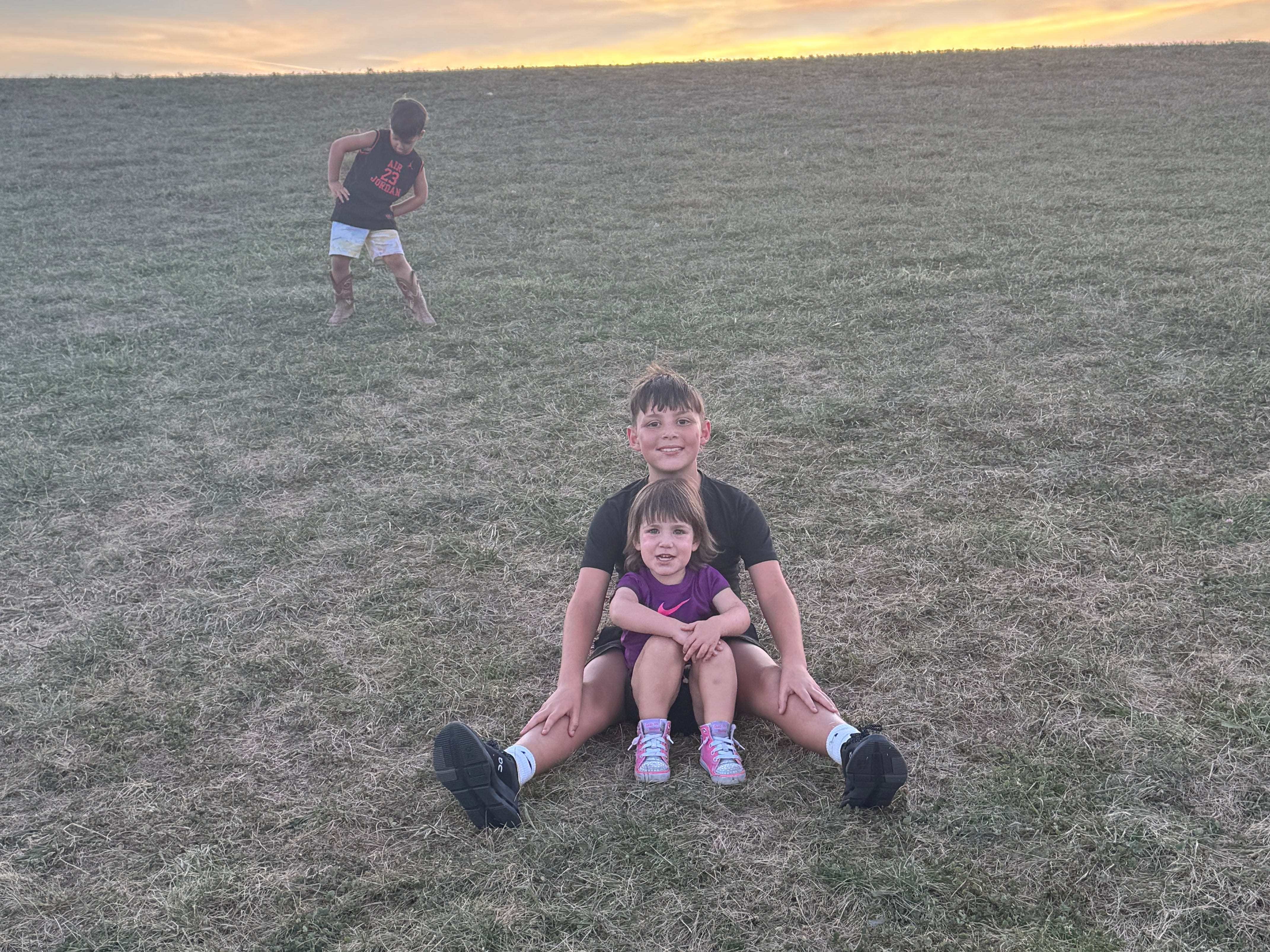 Alexandra Frost's kids playing on a grassy hill