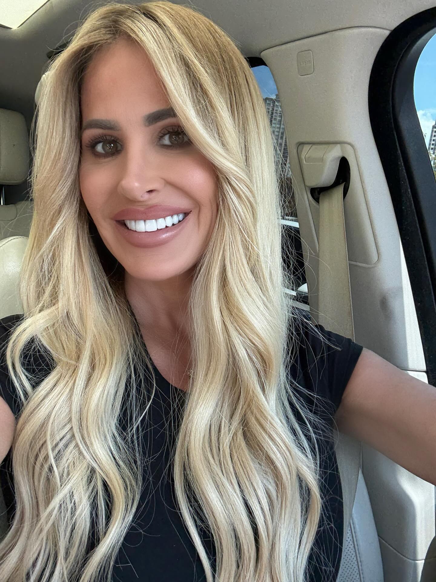 Kim Zolciak in a car with a seatbelt visible.