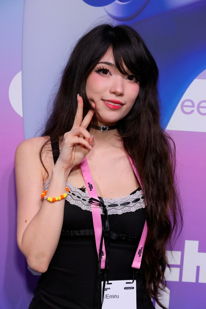 Streamer Emiru making a peace sign at TwitchCon 2024 San Diego.