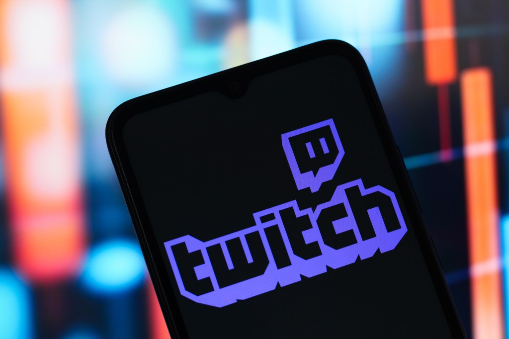 Photo illustration of a smartphone displaying the Twitch logo.