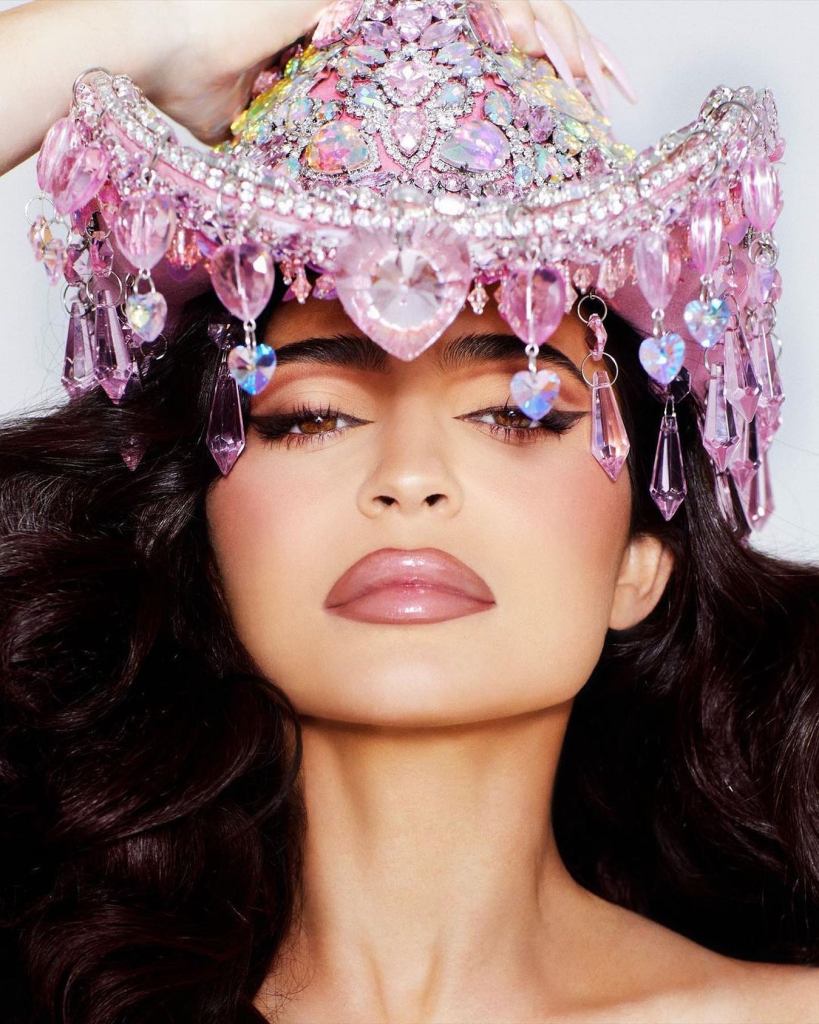 Kylie Jenner wearing a pink bejeweled crown with dangling heart and teardrop-shaped crystals.