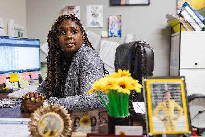 A black woman sitting at her desk in front of her computer.