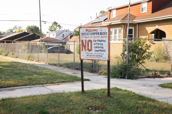 A sign in front of an empty yard reading No car washing, littering, loitering, or loud music.