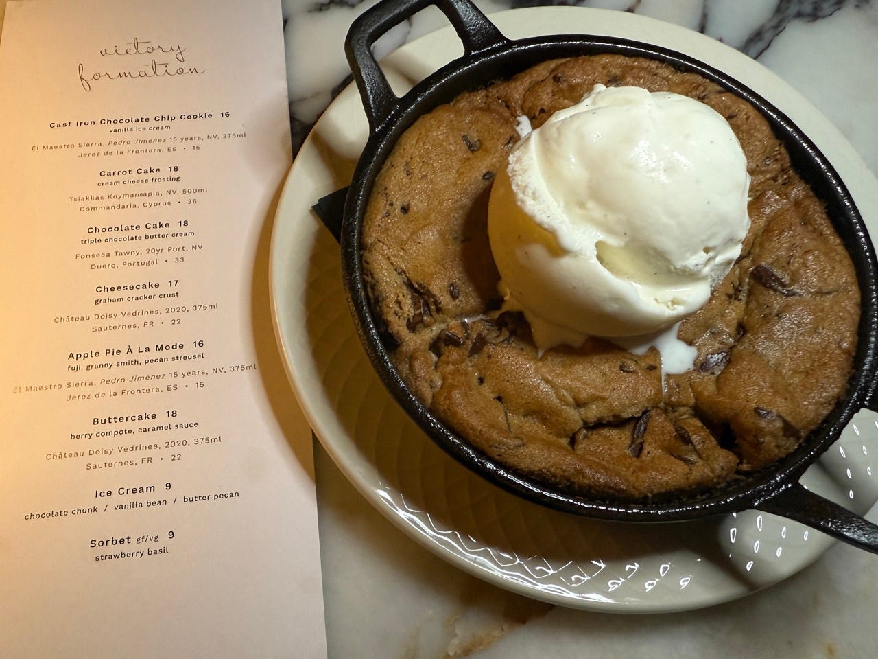 Cookie skillet with ice cream on top next to dessert menu