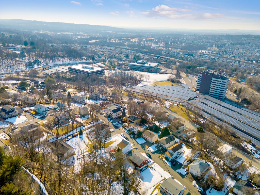 Aerial view of Paterson, New Jersey, featuring residential homes, a PNC building, and solar panels.